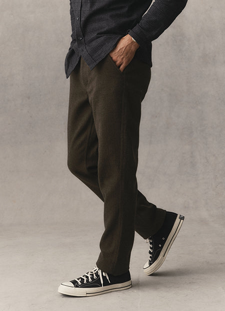 fit model posing in The Carnegie Pant in Smoked Olive Wool, by Taylor Stitch